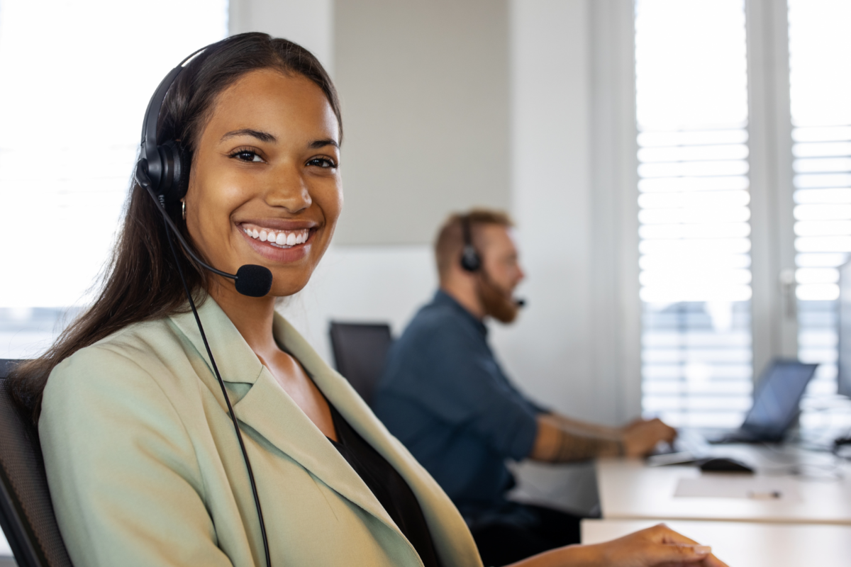 a customer representative working at a desk and smiling.