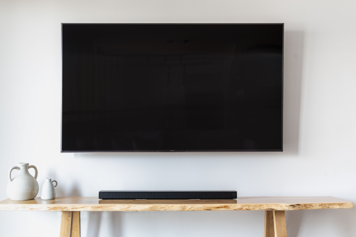 a flatscreen tv mounted on the wall in a home, which is a product that could be measured using an electric usage monitor.