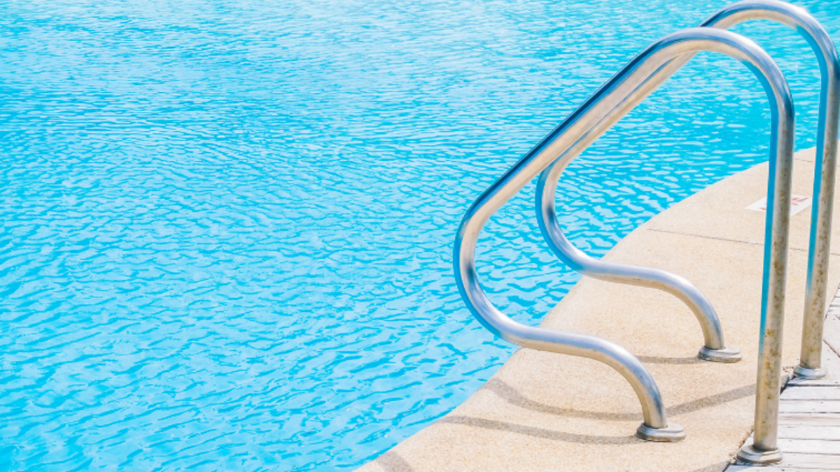 a metal ladder for an outdoor in-ground pool.