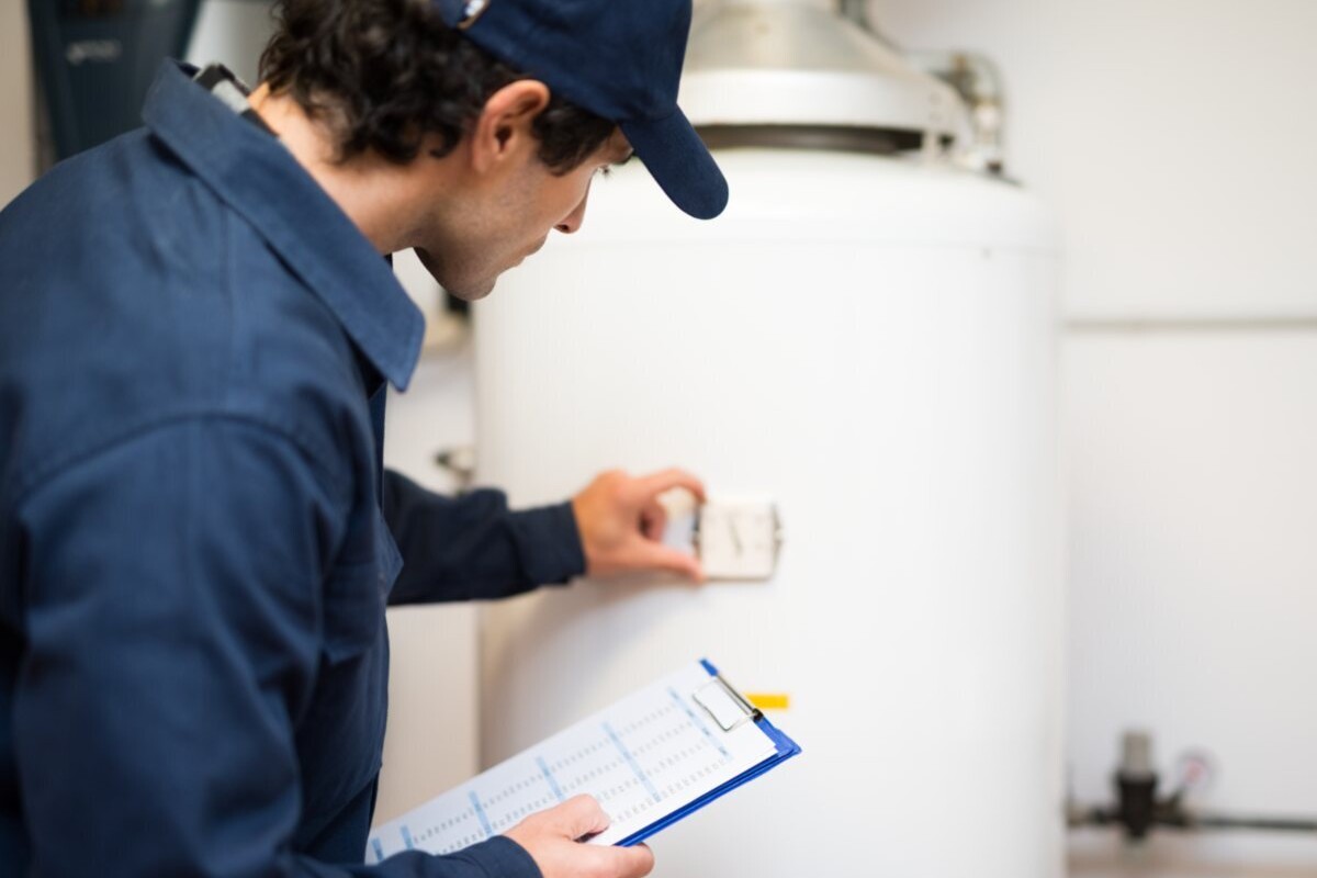 A technician adjust the temperature on a hat water heater