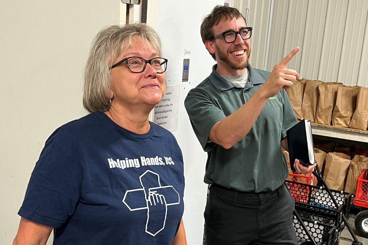 Kathrynn McElroy and an Efficiency Smart employee discuss efficiencies at the Helping Hands facility.