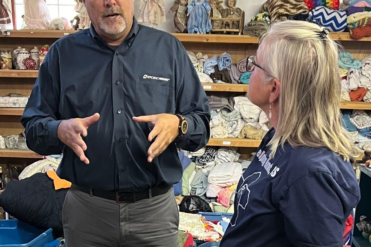 Efficiency Smart employee and Kathrynn McElroy converse at the Helping Hands facility
