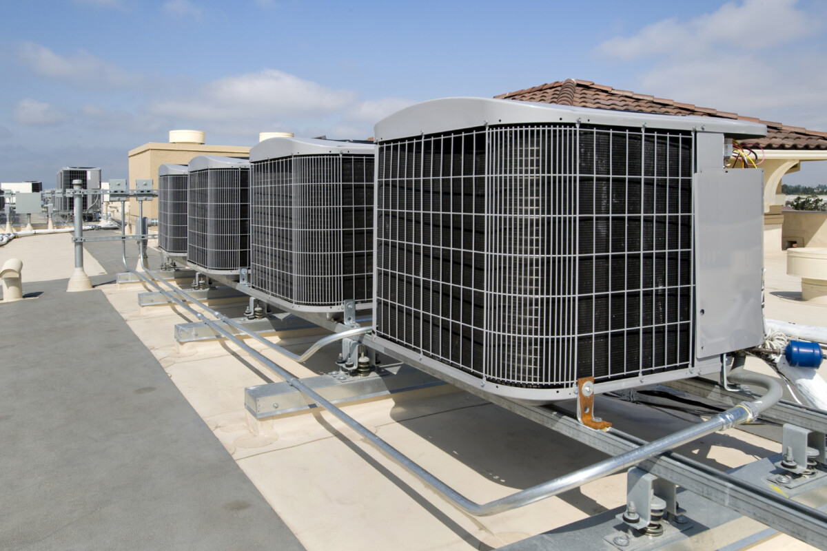 four commercial HVAC systems on the roof of a large building.