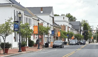 a street in downtown Smyrna, Delaware with cars parked along the street.