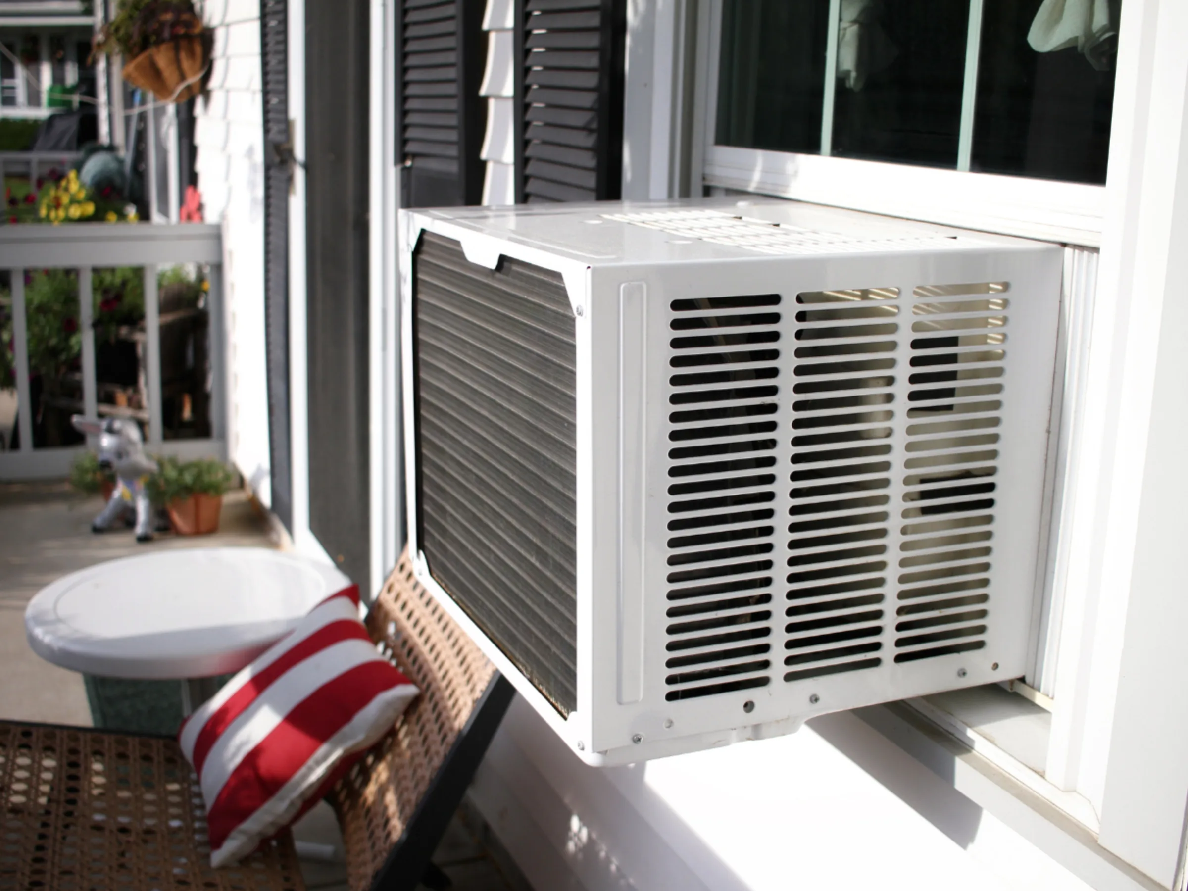 a porch with a window air conditioner unit installed on the house's window.