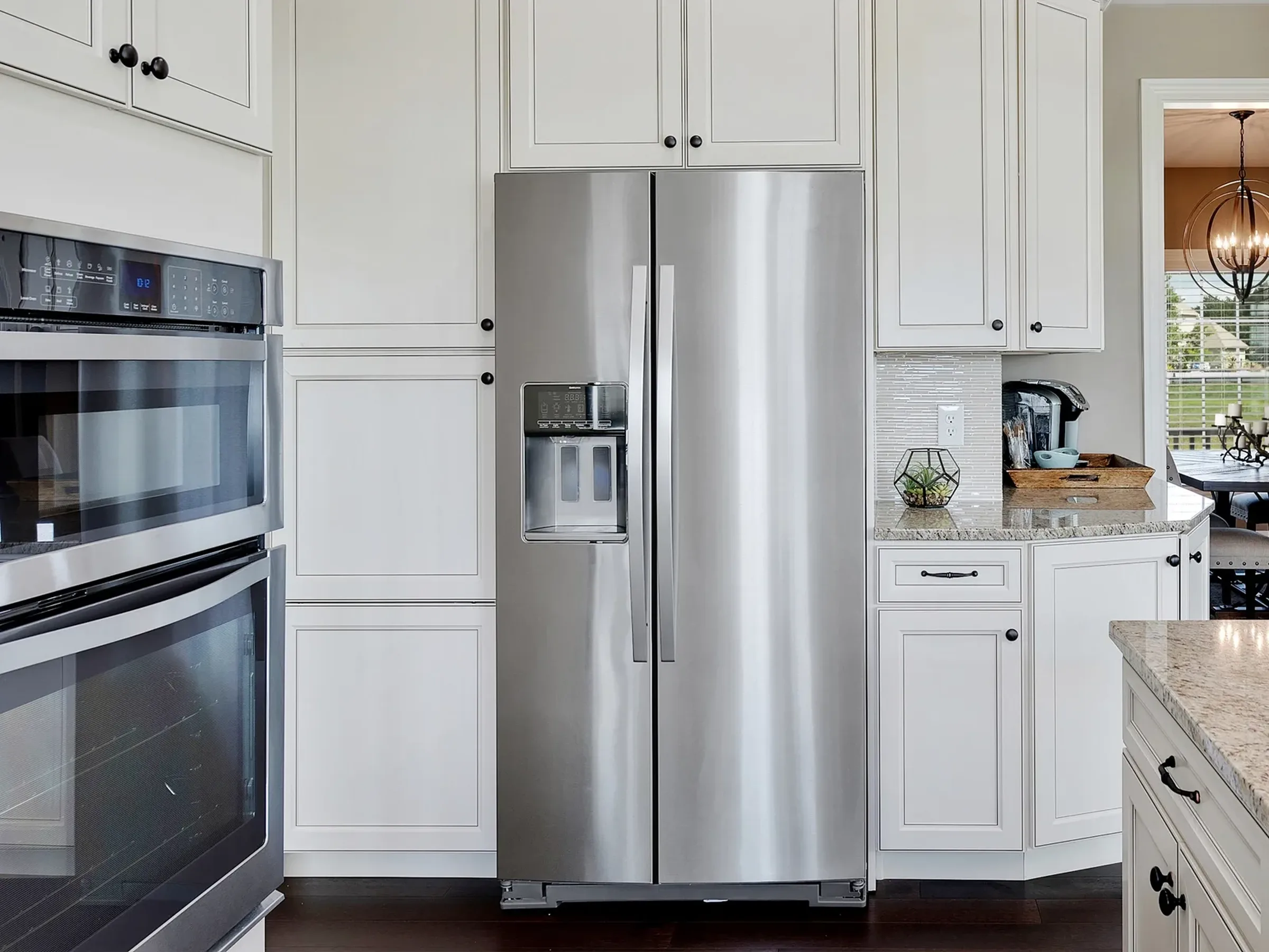 a silver, two door refrigerator in the kitchen of a home.