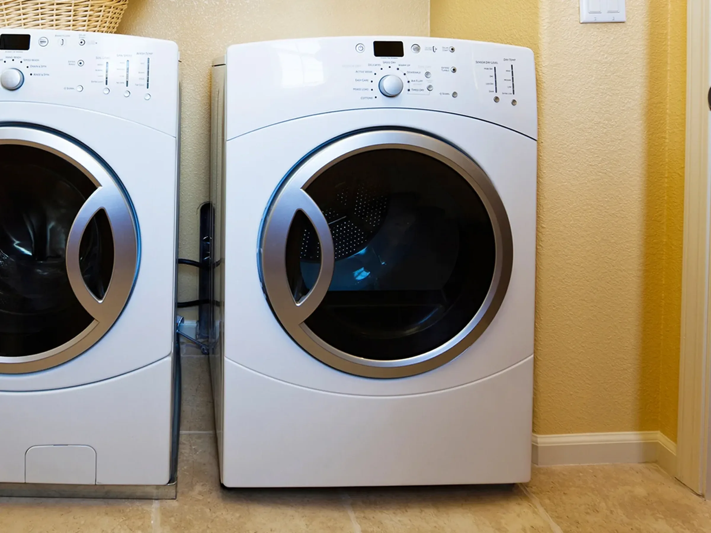 an electric clothes dryer unit next to a matching clothes washer.