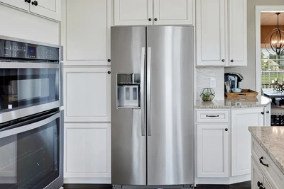 a silver, two door refrigerator in the kitchen of a home.