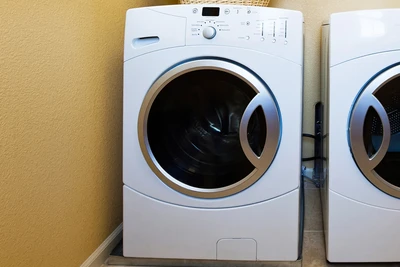 a clothes washing machine next to a matching electric clothes dryer unit.