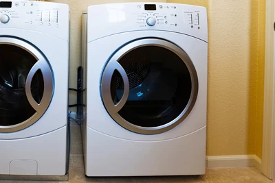 an electric clothes dryer unit next to a matching clothes washer.